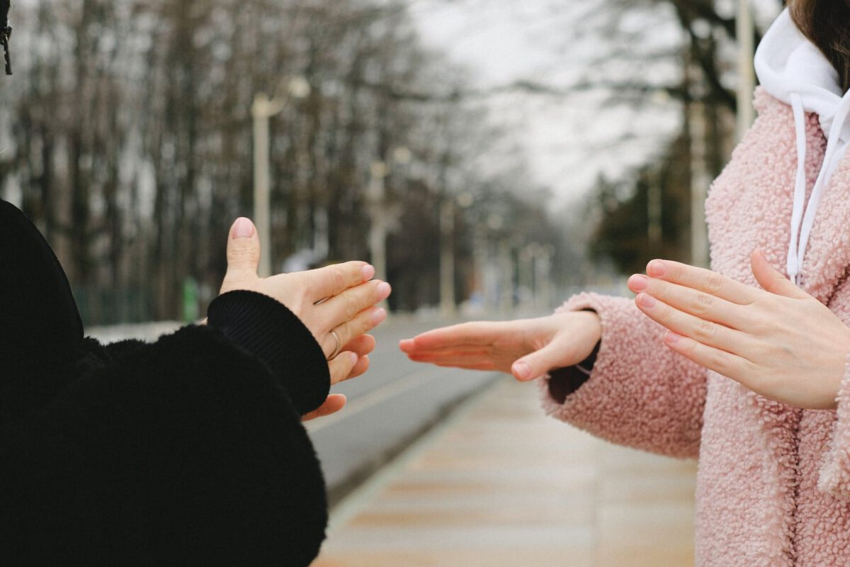 Two hands in sign language, with new signs in climate change