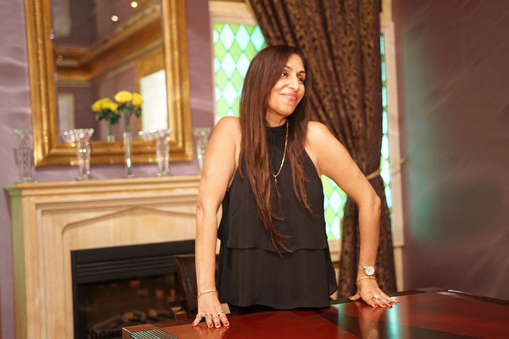 Woman with long hair standing at a shiny meeting desk