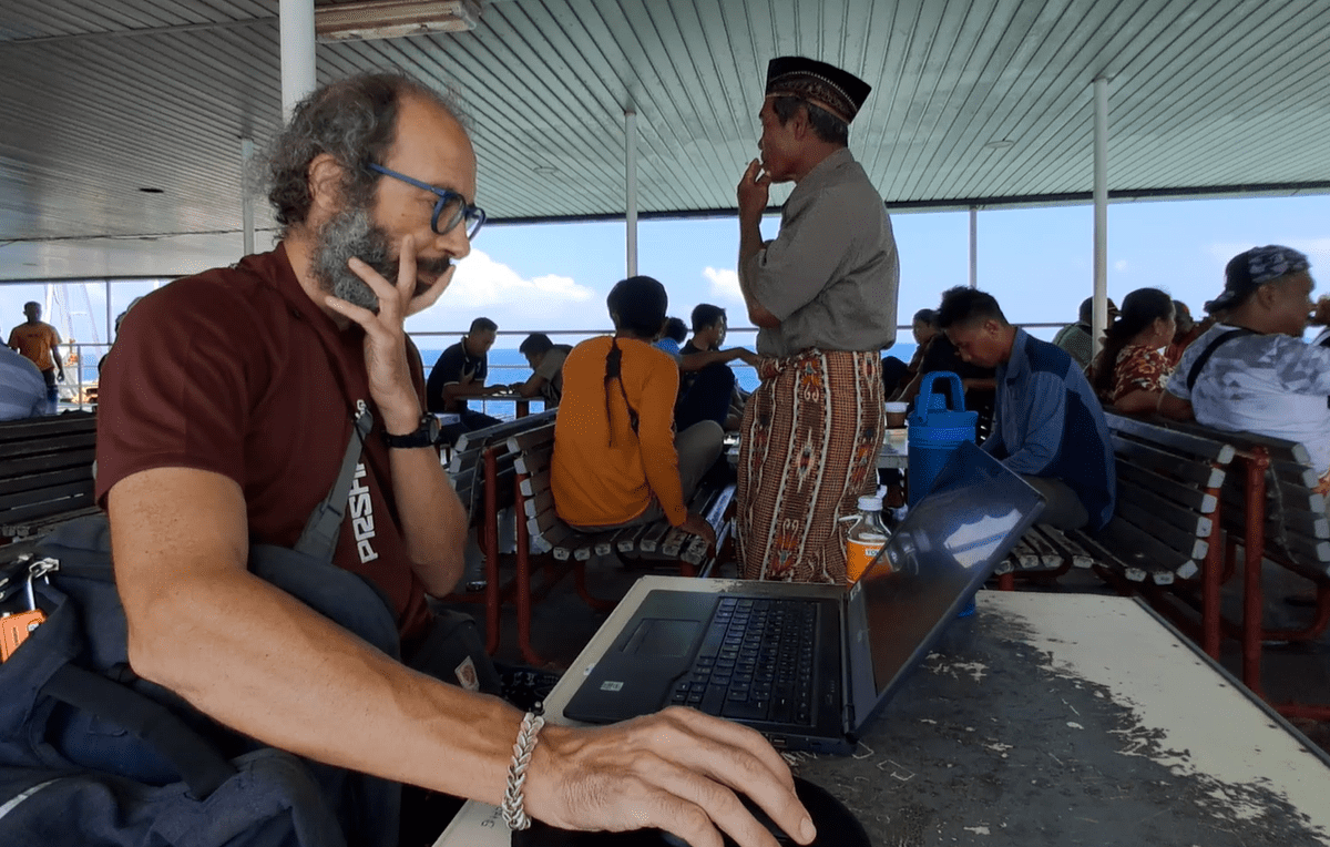 air travel environmental impact: man on a boat working on a laptop